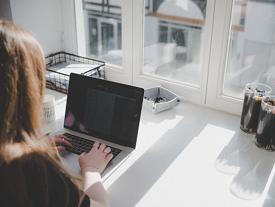 Junge Frau im Büro am Laptop