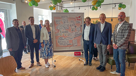 Foto: Eine Gruppe von Menschen steht um ein Plakat herum.