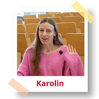 Polaroidfoto von Karolin in einem Hörsaal. Sie winkt in die Kamera.