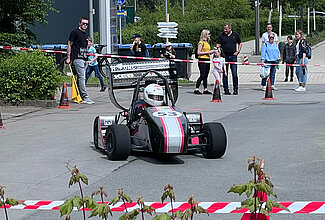 Rennwagen in Fahrt und Zuschauer