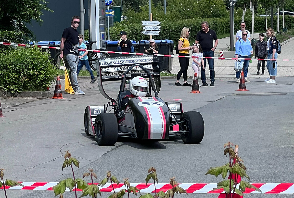 Rennwagen in Fahrt und Zuschauer