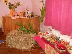 Esszimmer der Kita Sterntaler mit rosa gestrichenen Wänden und pinken Vorhängen, einer Holzkommode und verschiedenen Obst- und Gemüsesorten in geflochtenen Körben 