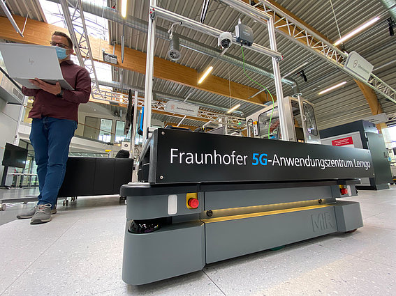 5G Anwendungszentrum Fraunhofer IOSB-INA Ein Mitarbeiter mit Laptop in der Smart Factory OWL