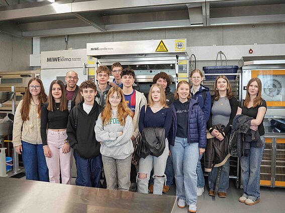 Eine Gruppe von Schüler:innen macht ein Gruppenfoto. 