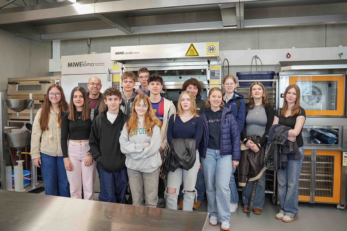 Eine Gruppe von Schüler:innen macht ein Gruppenfoto. 
