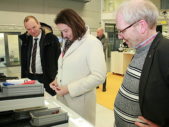 Regierungspräsidentin Anna Katharina Bölling baut nach Anleitung einer Automations-Software eine Lego-Eule. Professor Dr.-Ing. Holger Borcherding vom Fachbereich Elektrotechnik und Technische Informatik und TH OWL-Präsident Professor Dr. Jürgen Krahl schauen interessiert zu. Foto: TH OWL