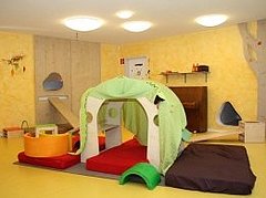 Gruppenraum der Musikkita Gruppenraum der Musikkita mit gelb gestrichenen Wänden, einer Spielhöhle und einem Kletterbaum