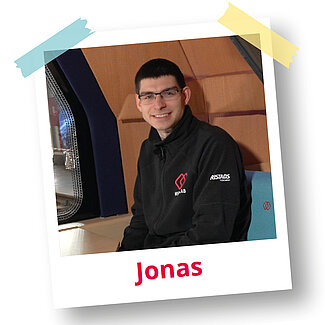 Polaroidfoto von Jonas mit Brille in der Kabine des MONOCAB mit Holzverkleidung.“