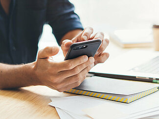 Hände tippen auf Smartphone