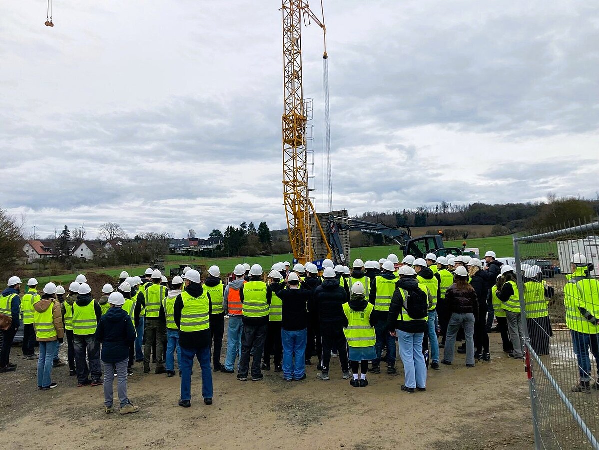 Foto: Teilnehmende der Projektwoche des Fachbereich Bauingenieurwesen besuchen eine Baustelle auf dem Campus Lemgo. Im Hintergrund steht ein Baukran.