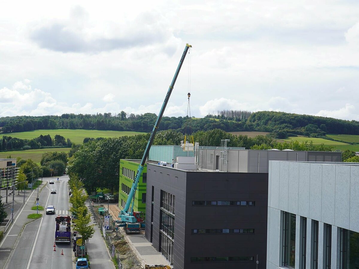Blick von weiter oben auf Flachdachbauten mit Autokran.