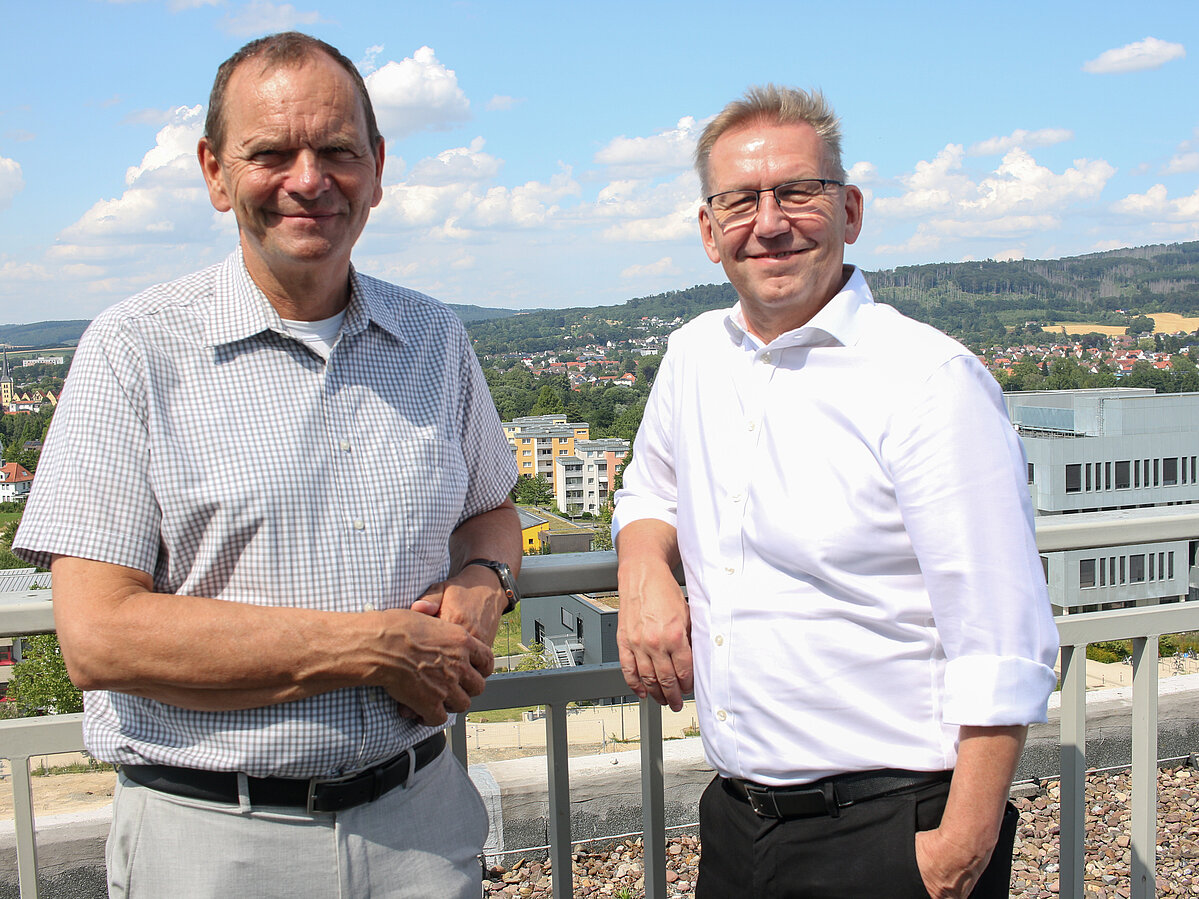 Professor Dr. Jürgen Krahl (links) und Jürgen Noch, Geschäftsführer von Westfalen Weser, stehen auf der Aussichtsplattform des Hauptgebäudes auf dem Innovation Campus Lemgo. Hinter ihnen ist das InnovationSPIN Gebäude sowie die Landschaft rund um den Campus zu sehen.