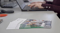 Aufgefächerte Flyer zu Stipendien auf einem Schreibtisch