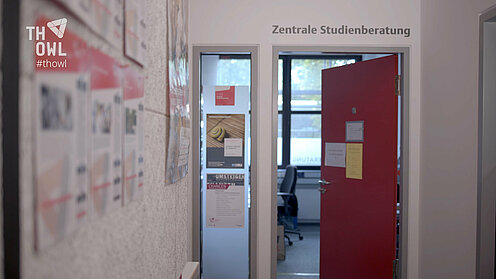 Rote geöffnete Tür, über deren Rahmen der Schriftzug Zentrale Studienberatung klebt.