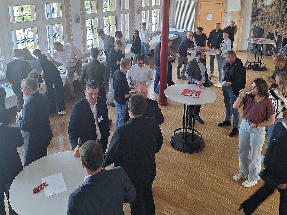 Symposiumsteilnehmende im Foyer beim Netzwerken.