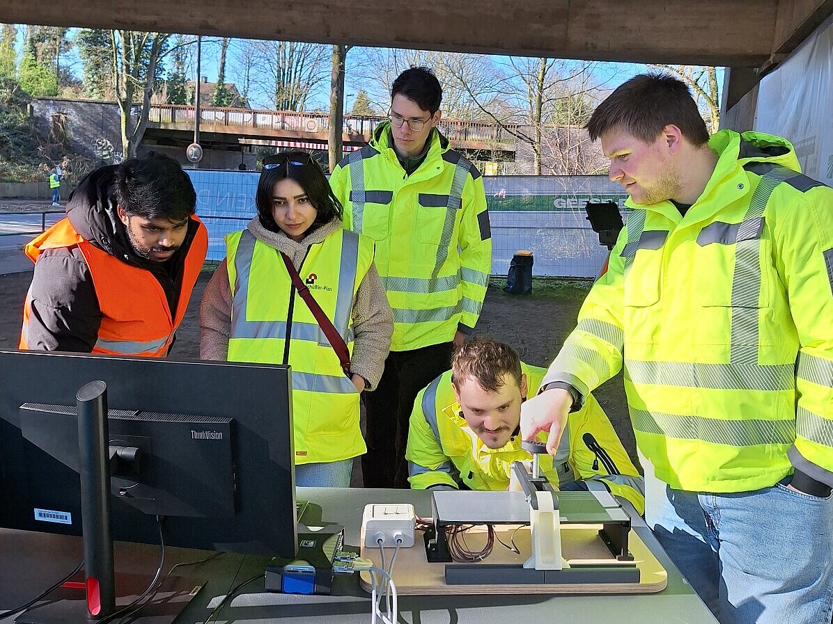 Fünf Personen vor Ort unter der Brücke analysieren und messen mit Computertechnik