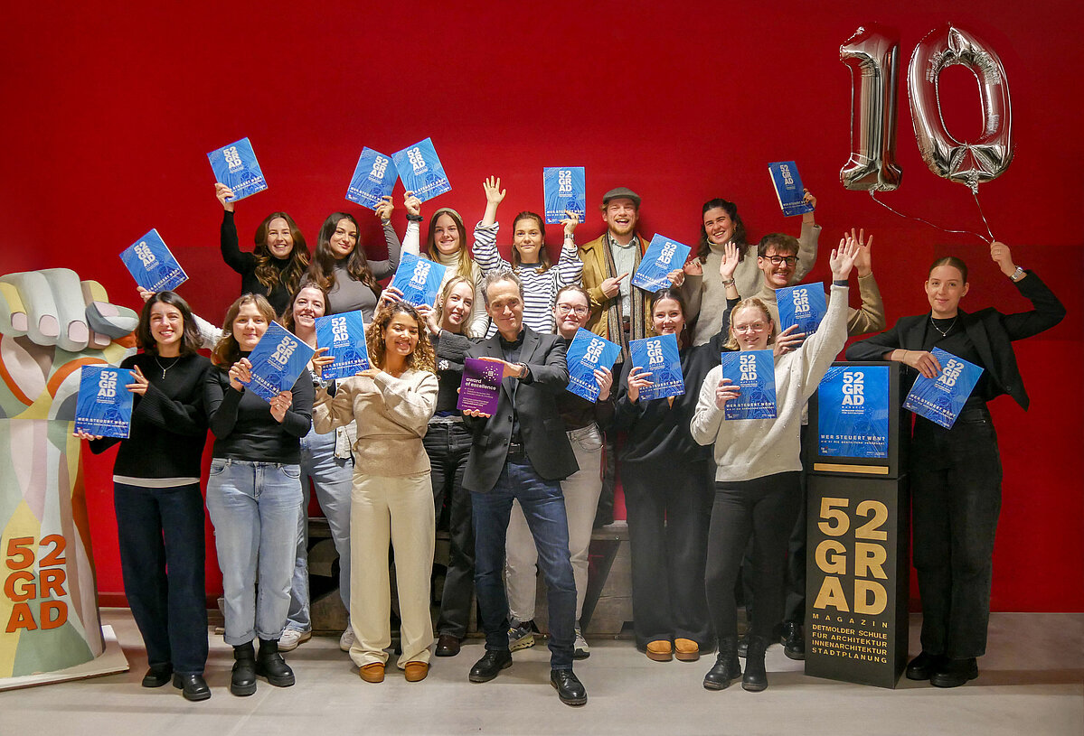 Große Gruppe von Studierenden und ihr Professor freuen sich über die Auszeichung. Halten Ausgaben des Magazins sowie eine 10 in die Höhe.