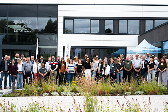Gruppenfoto der Teilnehmenden des 13. Netzwerktreffens von wasser^plus OWL vor dem Gebäude der Stadtwerke Detmold.