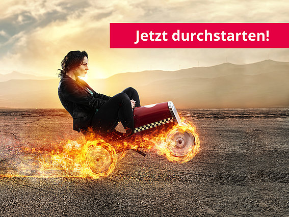 Junge Frau auf Bobbycar mit Raketenantrieb