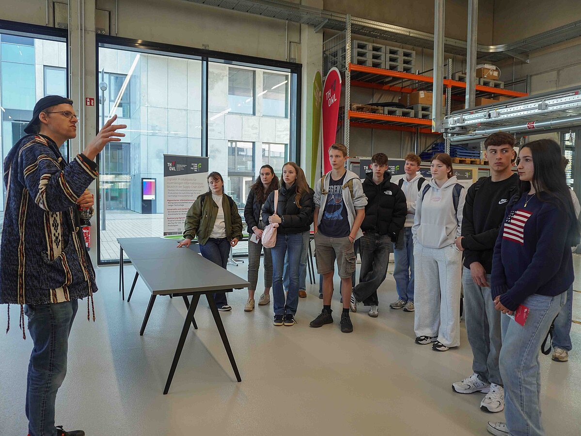 Ein Mann gibt einer Gruppe von Schüler:innen eine Führung durch die Future Food Factory