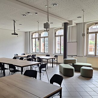 Raum mit individuell arrangierbaren Tischen und Stühlen