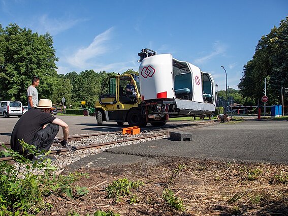 Photo: The MONOCAB test vehicle is being placed on the track by a forklift. 
