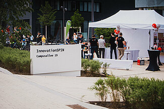 Weißer Pavillon mit Besuchenden vor InnovationSPIN.
