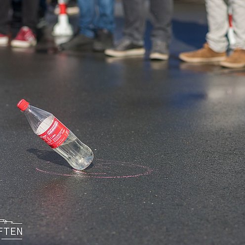 Umfallende Flasche symbolisiert das Campusleben