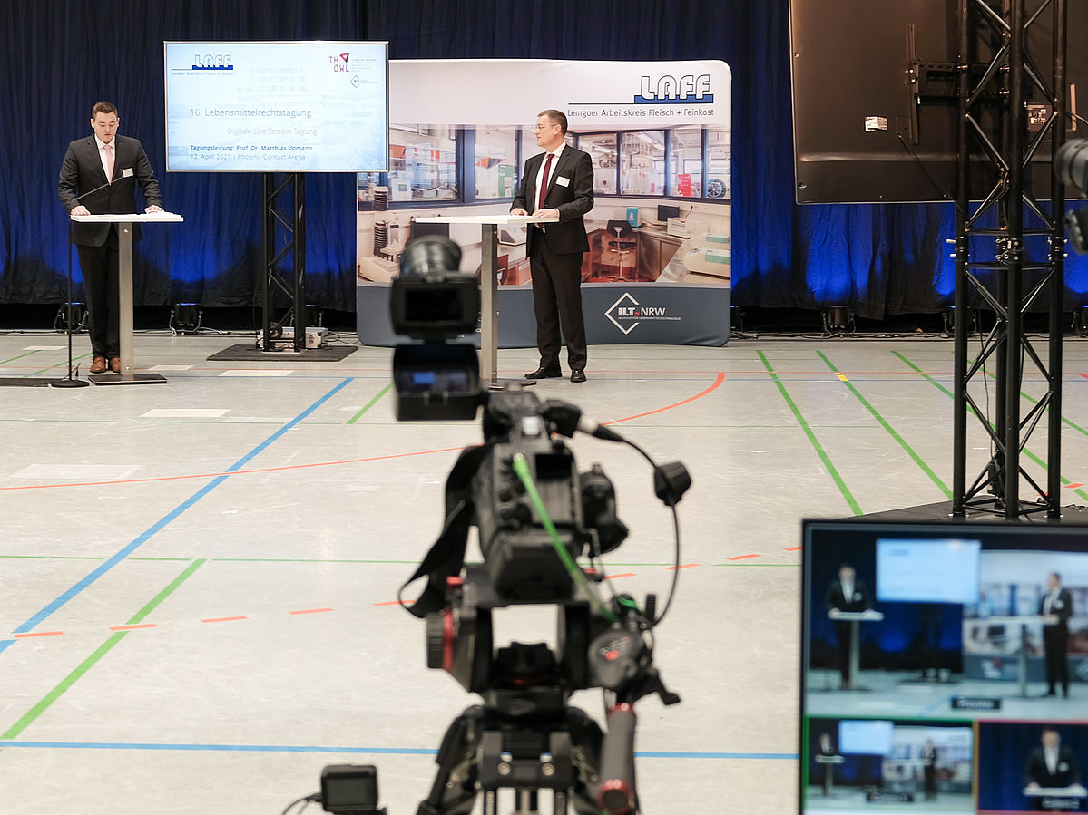 Der Preisträger des Internationalen LAFF Award 2020, Philipp Aßner (links), mit Laudator Prof. Dr. Matthias Upmann auf dem Podium, im Vordergrund für die Live-Übertragung der Tagung benötigtes Equipment wie Kamera und Bildschirm