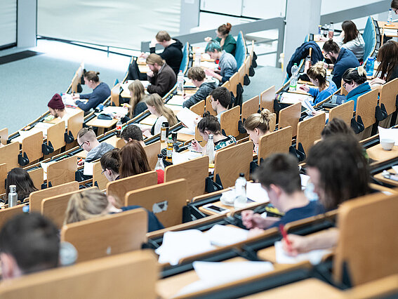 Photo: Students in the packed main lecture hall at TH OWL in Lemgo. The view is from the back rows, looking down to the right. 