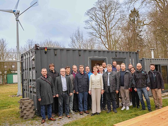 Eine Gruppe Menschen steht vor einer Anlage des KraftwerLands..