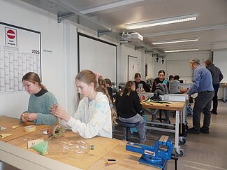 Eine Gruppe von Mädchen bastelt eine Wasserrakete.