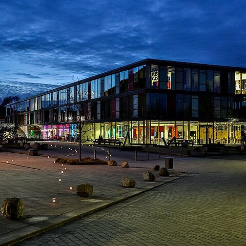 Das beleuchtete Gebäude 2 auf dem Kreativ Campus Detmold im Dämmerlicht