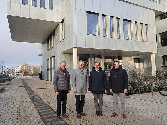 Vier Männer stehen vor dem InnovationSPIN auf dem Campus in Lemgo. 