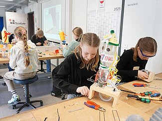 Zwei Mädchen tüfteln an ihren Wasserraketen. 