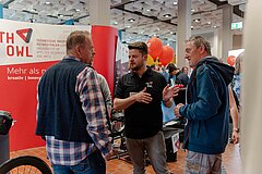 Zwei Männer unterhalten sich mit einem Studenten