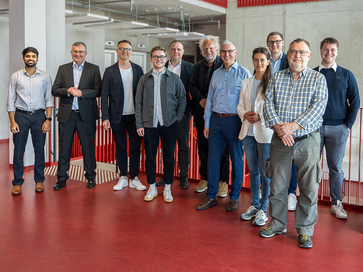 [Translate to Englisch:] Foto: Elf Personen, davon eine Frau, blicken in die Kamera.