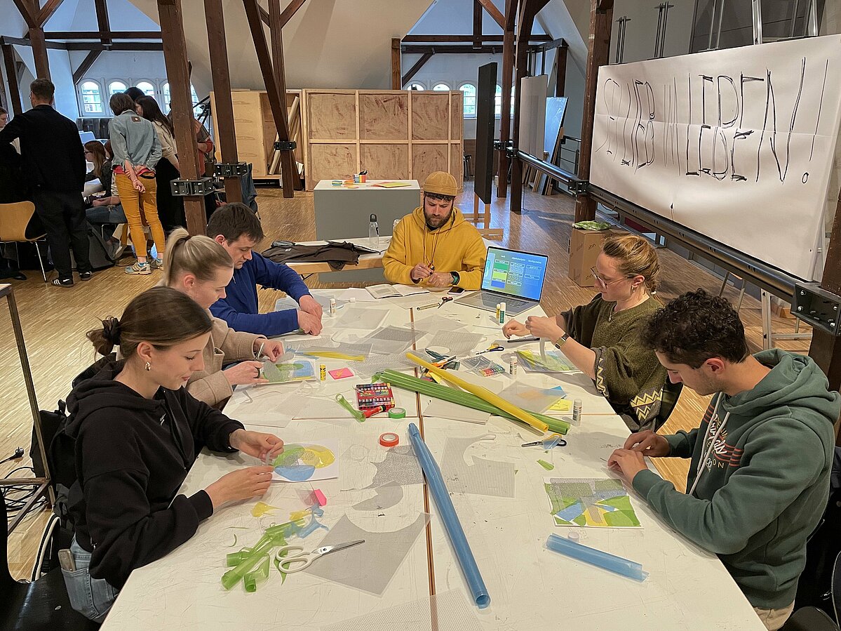 Teilnehmenden des Workshops arbeiten gemeinsam am Tisch.