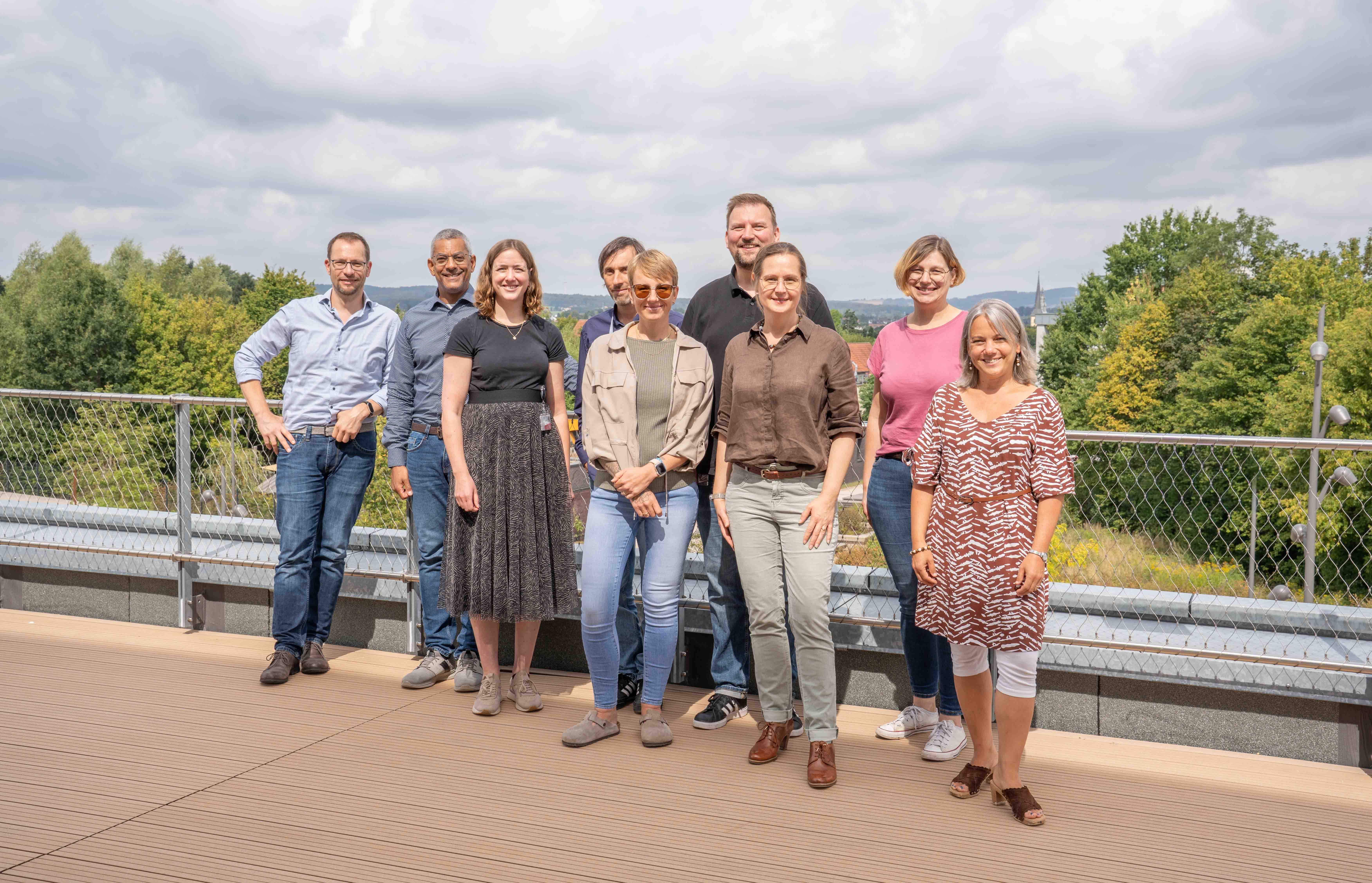 Foto: Neun Personen, davon vier Männer, stehen auf einer Terrasse des InnovationSPIN in Lemgo.